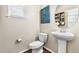 Elegant half bath with a pedestal sink, decorative mirror, and stylish fixtures at 4145 Manorbrier Cir, Castle Rock, CO 80104
