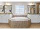 Bright bathroom featuring a soaking tub, double sinks, and granite countertops at 4145 Manorbrier Cir, Castle Rock, CO 80104
