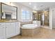 Bright bathroom featuring a soaking tub, double sinks, and walk-in shower at 4145 Manorbrier Cir, Castle Rock, CO 80104