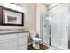 Bright bathroom features a shower with glass doors, granite counters, and wood look flooring at 4145 Manorbrier Cir, Castle Rock, CO 80104