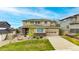 Inviting two-story home boasts a well-maintained lawn, charming brick accents, and an attached two-car garage at 4145 Manorbrier Cir, Castle Rock, CO 80104