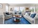 Bright living room with a large blue rug, three couches, and natural lighting at 4145 Manorbrier Cir, Castle Rock, CO 80104