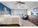 Bright main bedroom with a ceiling fan, comfy chair, and windows at 4145 Manorbrier Cir, Castle Rock, CO 80104