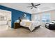 Spacious main bedroom featuring a blue accent wall, tray ceiling, and a leather chair at 4145 Manorbrier Cir, Castle Rock, CO 80104