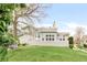 A wide shot of the backyard with a fenced patio, lawn and view of the two-story home at 6858 Zenobia St # 9, Westminster, CO 80030
