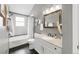 A clean bathroom with a shower-tub combo, white vanity, and stylish mirror, perfect for relaxation at 6858 Zenobia St # 9, Westminster, CO 80030