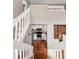 A view through the split staircase reveals a cozy kitchen with modern appliances and white cabinetry at 6858 Zenobia St # 9, Westminster, CO 80030