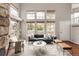 A living room area with a stone fireplace, vaulted ceiling, hardwood floors and a large window at 6858 Zenobia St # 9, Westminster, CO 80030