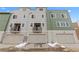 Exterior view of townhome garages, featuring neutral siding, overhead doors, and a balcony at 14281 Currant St, Broomfield, CO 80020