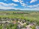 Scenic aerial view of a neighborhood with lush greenery, mountains in the distance and a tranquil lake at 1795 Eldorado Cir, Superior, CO 80027