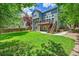 Spacious backyard with a well-manicured lawn, mature trees, and a two-story home with a deck at 1795 Eldorado Cir, Superior, CO 80027