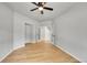 Neutral bedroom featuring a ceiling fan, light wood floors, and double doors leading to a hallway at 1795 Eldorado Cir, Superior, CO 80027