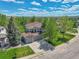 Aerial view of a two-story home with a brick and siding exterior, complemented by mature trees and a well-maintained lawn at 1795 Eldorado Cir, Superior, CO 80027