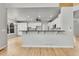 Kitchen featuring a long center island, white cabinets, hardwood floors, and open access to the adjacent room at 1795 Eldorado Cir, Superior, CO 80027