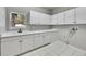 Bright laundry room featuring a sink, white cabinets, and white tile floors at 1795 Eldorado Cir, Superior, CO 80027
