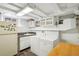 Functional laundry room with a washer, dryer, sink, cabinetry, and a folding table for convenience at 621 Kearney St, Denver, CO 80220