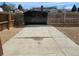 Fenced backyard featuring a concrete driveway and black gate to ensure privacy and security at 808 Idalia St, Aurora, CO 80011