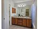 Bathroom with double sink vanity, wood cabinetry, and large mirror, offering ample space and functionality at 808 Idalia St, Aurora, CO 80011