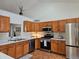 Kitchen with stainless steel appliances, wooden cabinets and light countertops at 808 Idalia St, Aurora, CO 80011