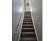 Carpeted staircase with a white handrail, leading to the upper level of the home at 808 Idalia St, Aurora, CO 80011