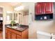 Bathroom featuring a granite countertop, wood cabinets, and red accent medicine cabinet at 11398 W Ford Pl, Lakewood, CO 80226