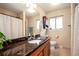 Neutral bathroom featuring a granite countertop, wood cabinets, and large mirror at 11398 W Ford Pl, Lakewood, CO 80226