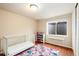 Bright bedroom with a crib, wood floors, and a colorful rug at 11398 W Ford Pl, Lakewood, CO 80226