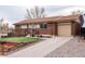 Lovely brick house features a front porch, well-manicured lawn, and an inviting driveway at 11398 W Ford Pl, Lakewood, CO 80226