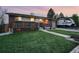 Well-maintained lawn and charming front porch with space for seating in front of brick home at 11398 W Ford Pl, Lakewood, CO 80226