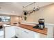 Bright kitchen with butcher block countertop and white cabinetry at 11398 W Ford Pl, Lakewood, CO 80226
