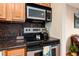 Kitchen area showcasing stainless steel oven, cooktop, microwave and granite countertops at 11398 W Ford Pl, Lakewood, CO 80226