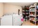 Functional laundry room with washer, dryer, and ample shelving for storage at 11398 W Ford Pl, Lakewood, CO 80226