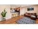 Open-concept living space with hardwood floors, a comfortable sofa, and a breakfast bar with seating at 11398 W Ford Pl, Lakewood, CO 80226