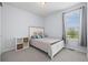 Light-filled bedroom has white furniture, patterned bedding, and a window with a view at 15604 Xenia Way, Brighton, CO 80602