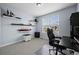 Neutral bedroom with shelves displaying collectibles and a black desk at 15604 Xenia Way, Brighton, CO 80602