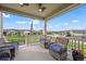 Inviting covered patio with wicker seating and a beautiful neighborhood view at 15604 Xenia Way, Brighton, CO 80602