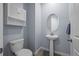 Elegant powder room with pedestal sink, oval mirror, and modern fixtures at 15604 Xenia Way, Brighton, CO 80602