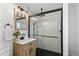 Stylish bathroom featuring subway tile shower with black hardware and a wood vanity at 5463 Shoshone St, Denver, CO 80221