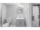 Modern bathroom featuring gray vanity with modern fixtures and a sliding barn door at 5463 Shoshone St, Denver, CO 80221