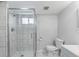 Bathroom featuring glass shower, white tile, and gray vanity with modern fixtures at 5463 Shoshone St, Denver, CO 80221