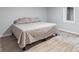 Neutral bedroom featuring a bed with a gray comforter and wood flooring at 5463 Shoshone St, Denver, CO 80221