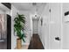 Hallway with hardwood floors and white walls leads to various rooms, showcasing natural lighting at 5463 Shoshone St, Denver, CO 80221