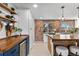 Modern kitchen featuring a brick accent wall, wood counters, island seating, and stainless steel appliances at 5463 Shoshone St, Denver, CO 80221