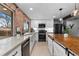 Modern kitchen with black appliances, a farmhouse sink, and a central island featuring a wood top at 5463 Shoshone St, Denver, CO 80221