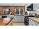 Bright kitchen with a farmhouse sink, brick wall, and modern appliances, including a black range at 5463 Shoshone St, Denver, CO 80221