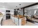 Well-lit kitchen with an island and seating overlooks the living room; great for entertaining at 5463 Shoshone St, Denver, CO 80221