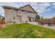 View of backyard showing a green lawn and patio with dining and lounge furniture at 5975 Hanover St, Denver, CO 80238