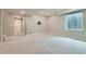 Finished basement with neutral walls and carpet, window, and door leading to stairs at 5975 Hanover St, Denver, CO 80238