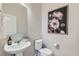 Tastefully decorated half bathroom with pedestal sink, stylish fixtures, and decorative art at 5975 Hanover St, Denver, CO 80238
