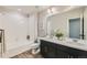 Bathroom with dual sink vanity, large mirror, shower over tub and modern fixtures at 5975 Hanover St, Denver, CO 80238